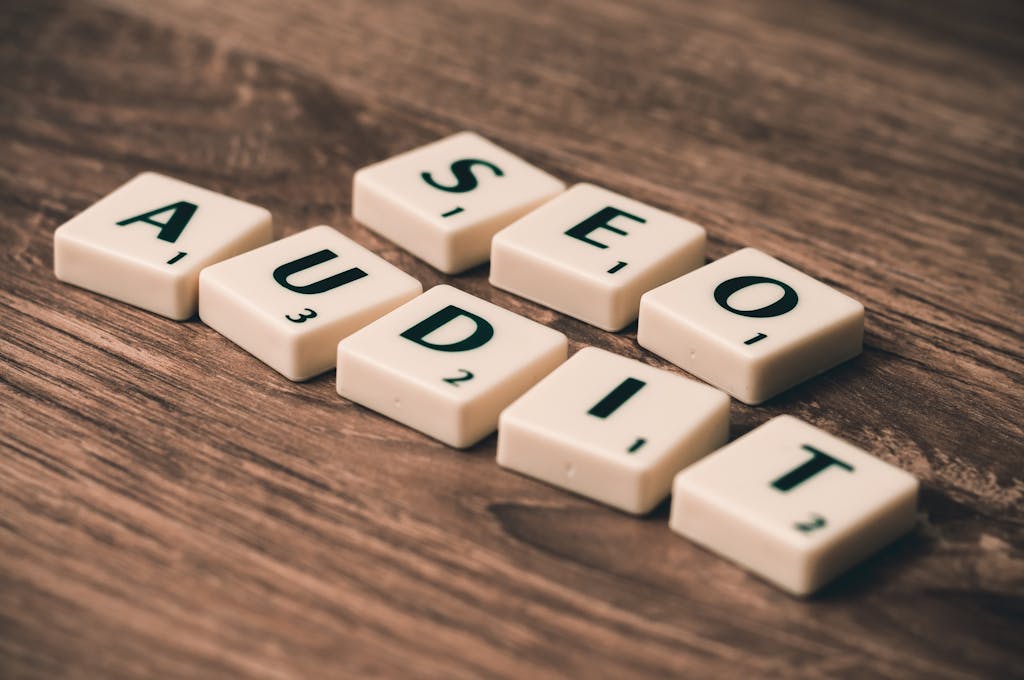 SEO Diego. Consultor SEO profesional 11 Primer plano de fichas de letras que deletrean "SEO Audit" en un soporte de madera
